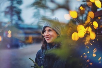 Smiling woman in warm clothing against sky