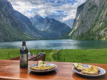 Scenic view of lake by mountains against sky