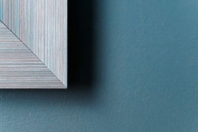 Cropped image of picture frame against blue wall