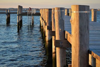 Wooden jetty on pier by sea against sky