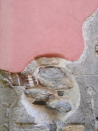 Close-up of old sculpture against wall