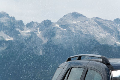 Airplane flying over snowcapped mountains against sky