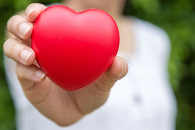 Close-up of woman holding heart shape