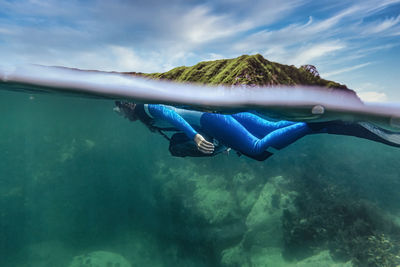 Woman in diving suit diving undersea