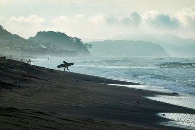 Man on beach against sky