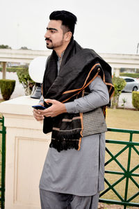 Young man using mobile phone standing outdoors