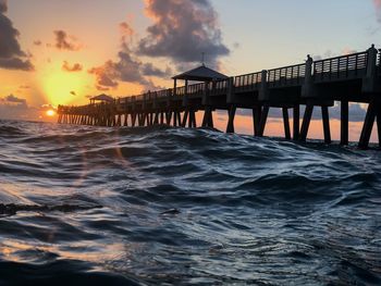 Pier over sea against sky during sunset