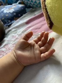 Close-up of baby hand on bed