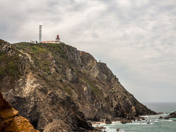 Rock formations by sea against sky