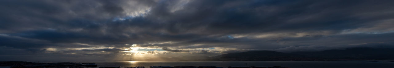 Scenic view of sea against dramatic sky during sunset
