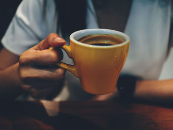 Midsection of man holding coffee cup