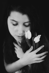 Portrait of woman holding red flower