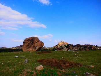 Rocks on field against sky