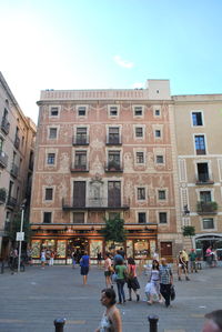 People walking on street against buildings in city