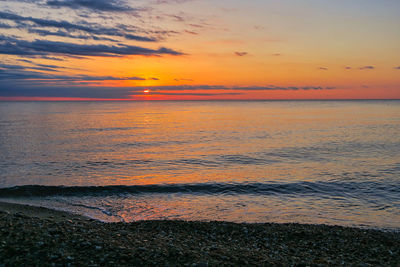 Scenic view of sea against romantic sky at sunset