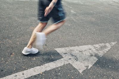 Low section of person walking on road