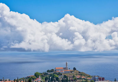 Buildings in city against cloudy sky