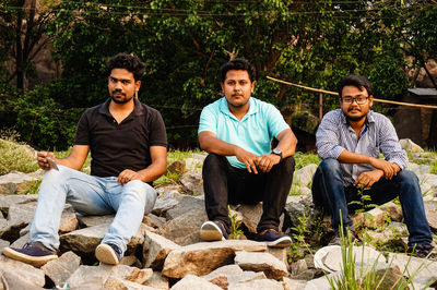 Portrait of smiling young men sitting outdoors