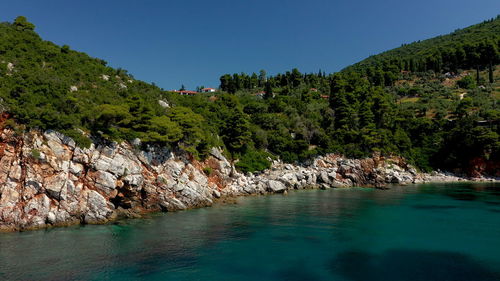 Scenic view of rocks against clear blue sky