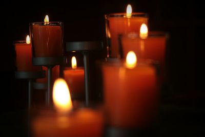 Lit candles against black background