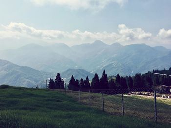 Scenic view of field and mountains against sky