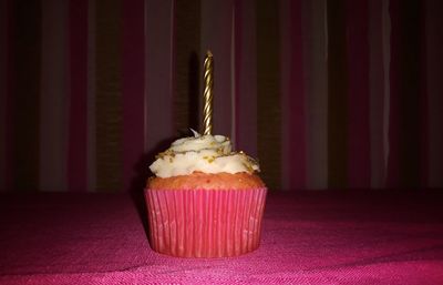 Close-up of candle in cupcake on table