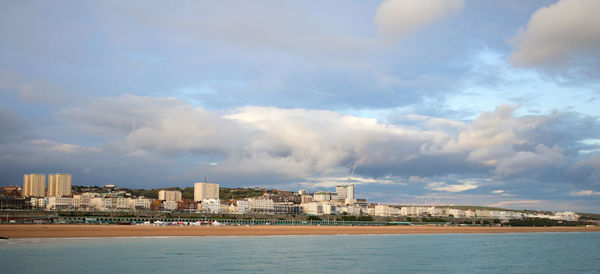 Sea by buildings against sky in city