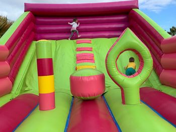 Siblings playing on bouncy castle