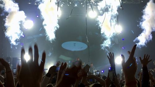 Panoramic view of people enjoying music concert at night