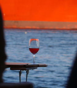 Close-up of beer in sea against sky during sunset