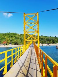 Bridge over water against clear blue sky