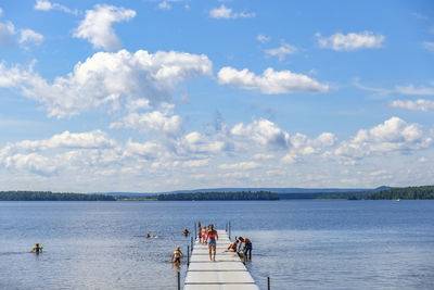 People on boat in sea against sky