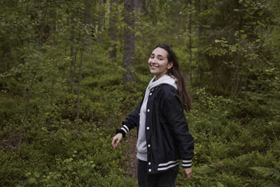 Smiling woman in forest looking at camera