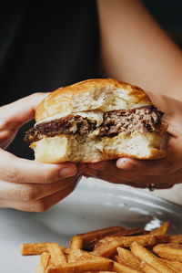 Close-up of hands holding burger