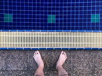 Low section of man standing at poolside