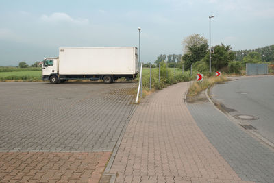 Vehicles on road against sky in city