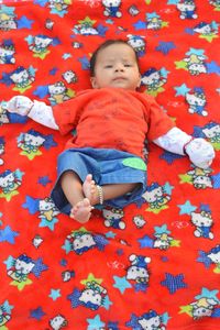 High angle view of baby lying on bed