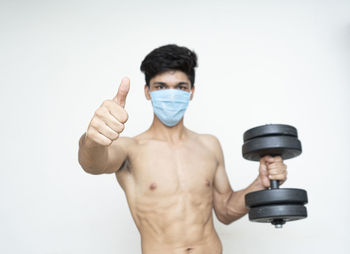 Portrait of shirtless man standing against white background