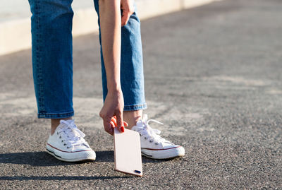 Low section of woman standing on footpath
