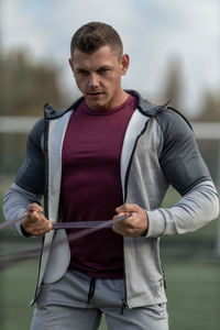 Side view of young man standing in park