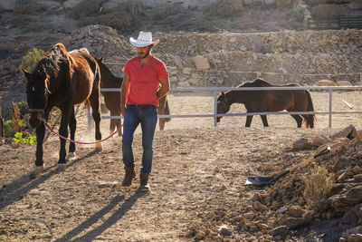 Full length of man and horse walking on land