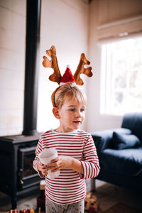 Boy holding coffee cup at home