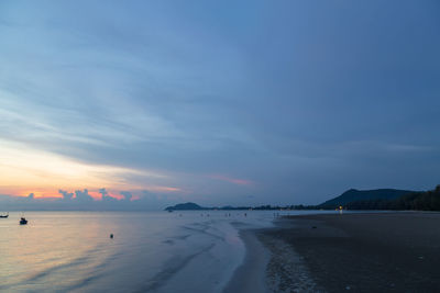 Scenic view of beach against sky at sunset
