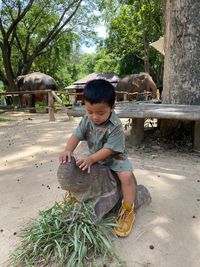 Side view of boy playing with straw at beach