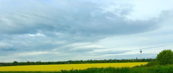 Scenic view of field against cloudy sky