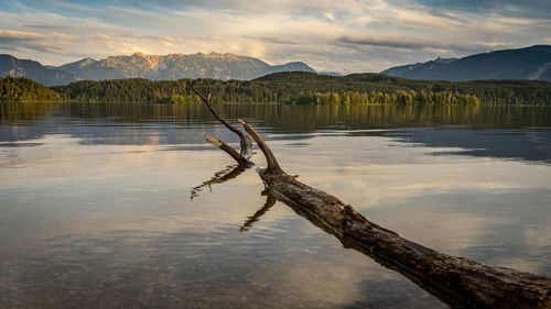 Scenic view of lake by mountains against sky