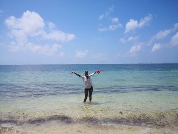 Full length of man standing at beach against sky