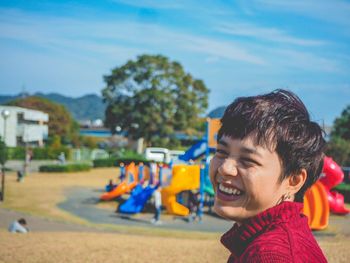 Boy enjoying at playground against sky