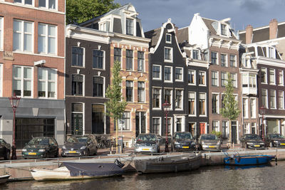 Boats moored on canal by buildings in city