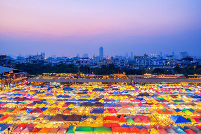 High angle view of illuminated city against sky at dusk